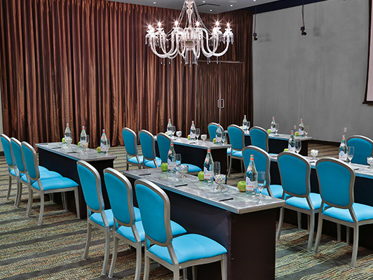 tables set up with blue chairs at a meeting room