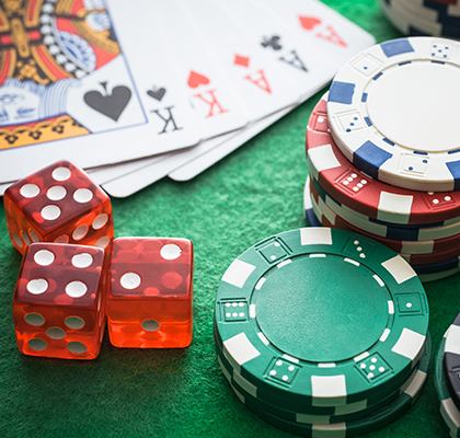 close up view of a poker table with poker chips, dices and cards