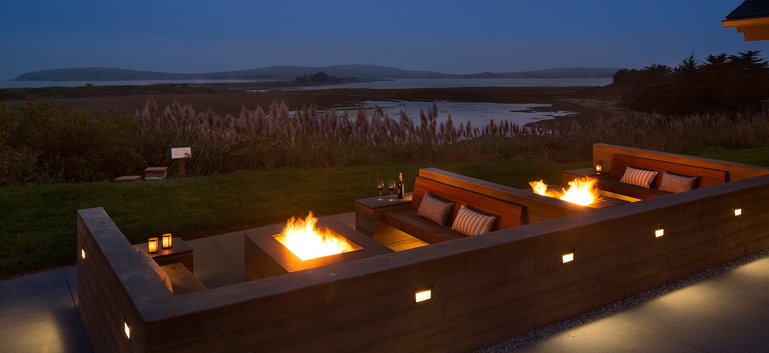 Night view of outdoor lounge area with fire pits