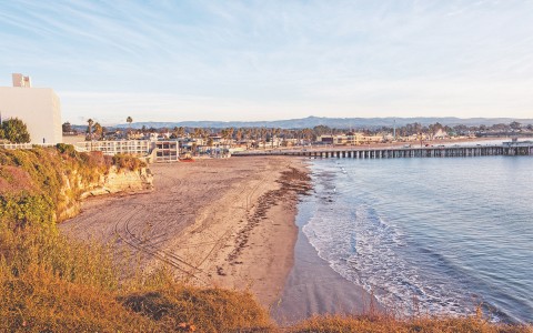 view of property, beach, ocean and pier
