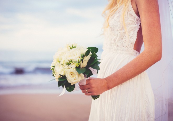 blonde bride on beach with white rose bouquet