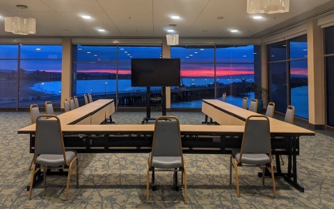 hotel meeting room overlooking the ocean with a beautiful blue and pink sunset