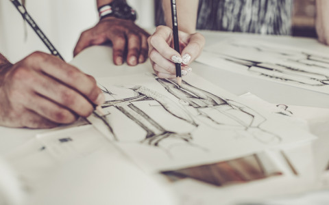two people working on a fashion sketch