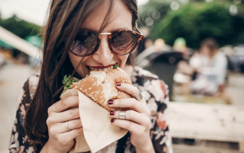 woman eating a burger outside