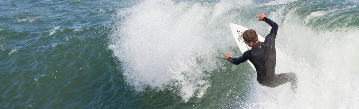 man surfing a wave in a wet suit