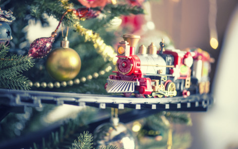 toy train driving around a christmas tree