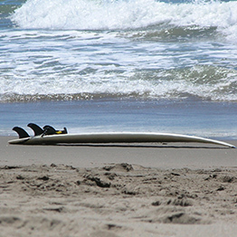 surfboard sitting on sand