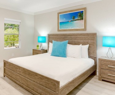 King Bed with white bedding and turquoise accent pillow