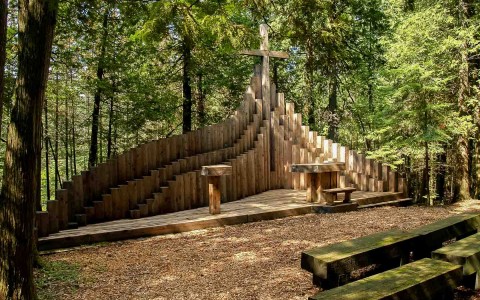 wedding ceremony spot in wooded area with a backdrop of wooden cross