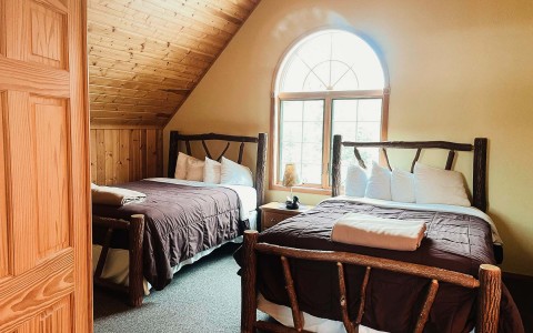 two bed in upstairs vaulted ceiling cabin room