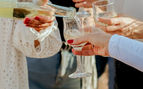 ladies gathered in loose circle pouring wine into glasses
