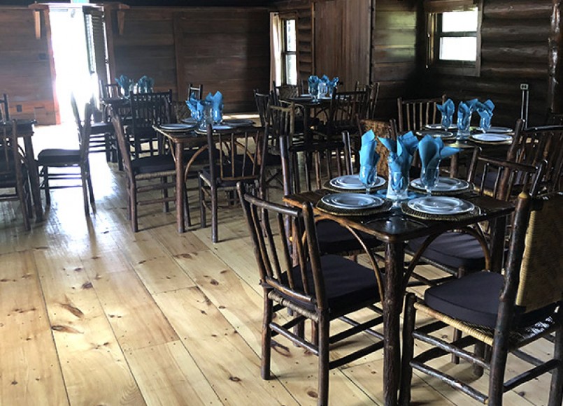 Log cabin inspired dining room with tables set for dinner