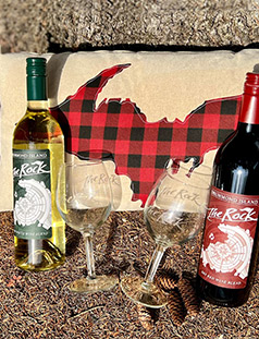 bottle of red and white wine and 2 wine glasses