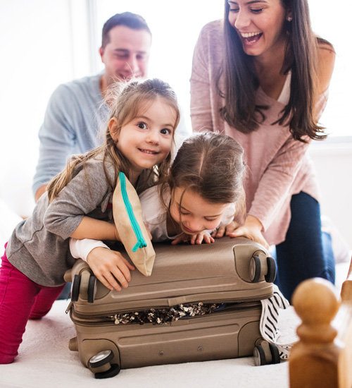Family laughing packing suitcase