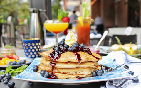 Close up of pancake stack with blueberries & syrup