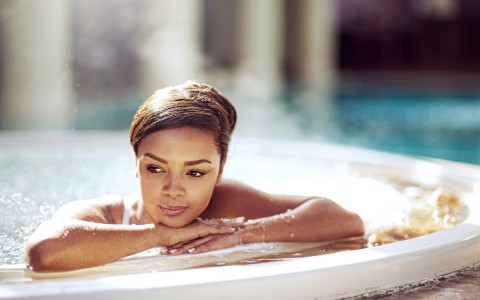 A woman laying at the jacuzzi edge