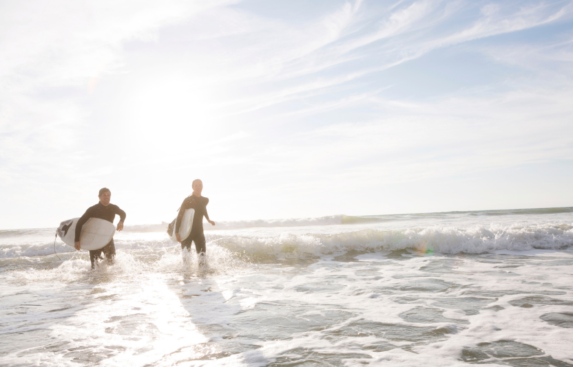 surfers walking into the ocean
