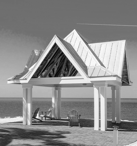 view of a small pavilion with chairs underneath it next to the ocean