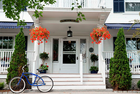 exterior view of kennebunkport inn with a blue bike and orange flowers in front