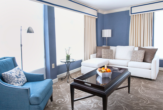 view of a white couch and blue chair with a black coffee table at hamilton hotel
