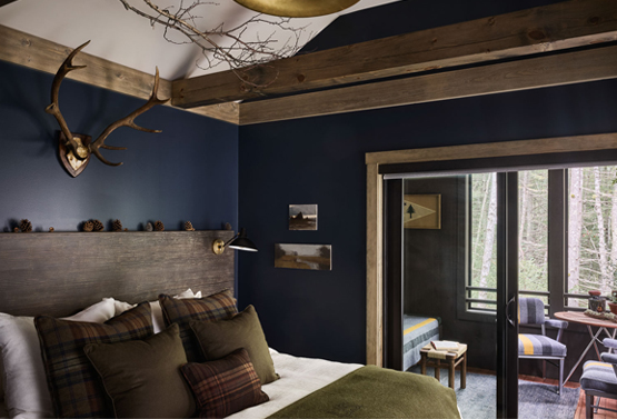 a cabin themed bedroom with antlers above the bed at hidden pond