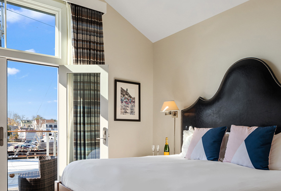 partial view of a king bed in a bedroom overlooking the marina at boathouse
