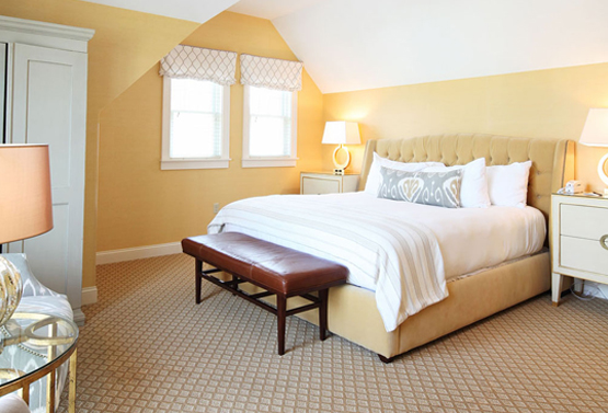 spacious yellow bedroom with a king bed at grand hotel