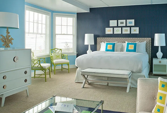 a king bed in a large light blue and navy bedroom at tides beach club maine