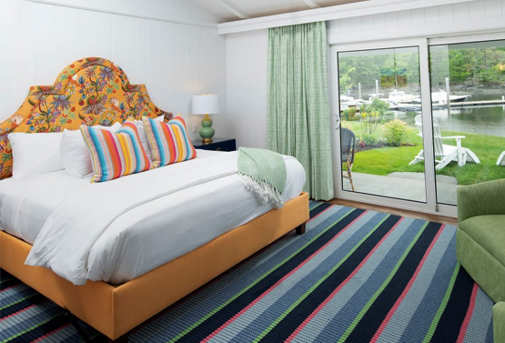 a king bed on a colorful bed frame in a room looking at the lake at yachtsman lodge