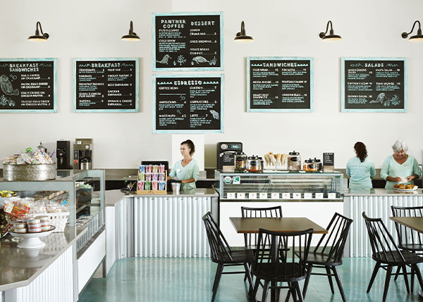a cafe with three employees behind the counter working