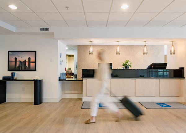 a woman walking through a lobby with her luggage
