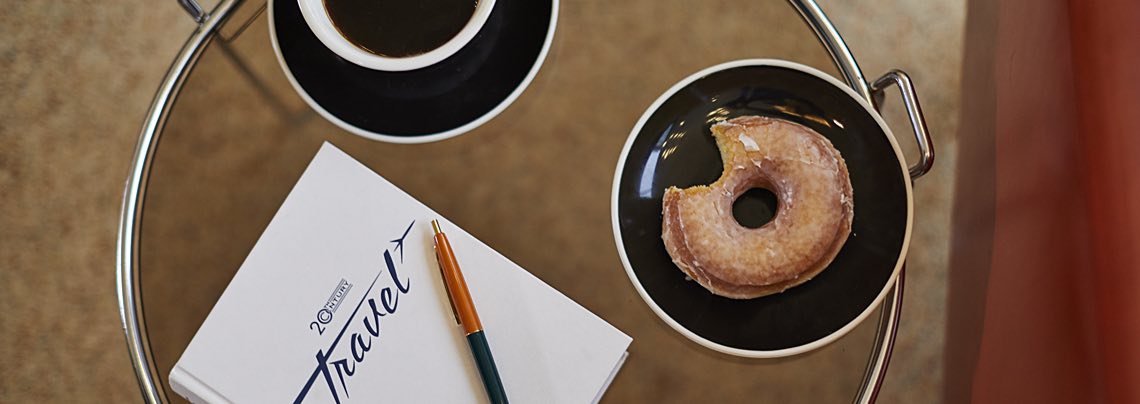 Glass table with donut, coffee and notebook
