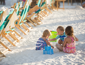 Three toddlers building sandcastles