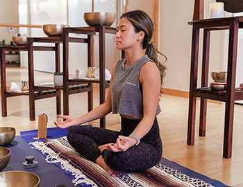 woman meditating on a yoga mat