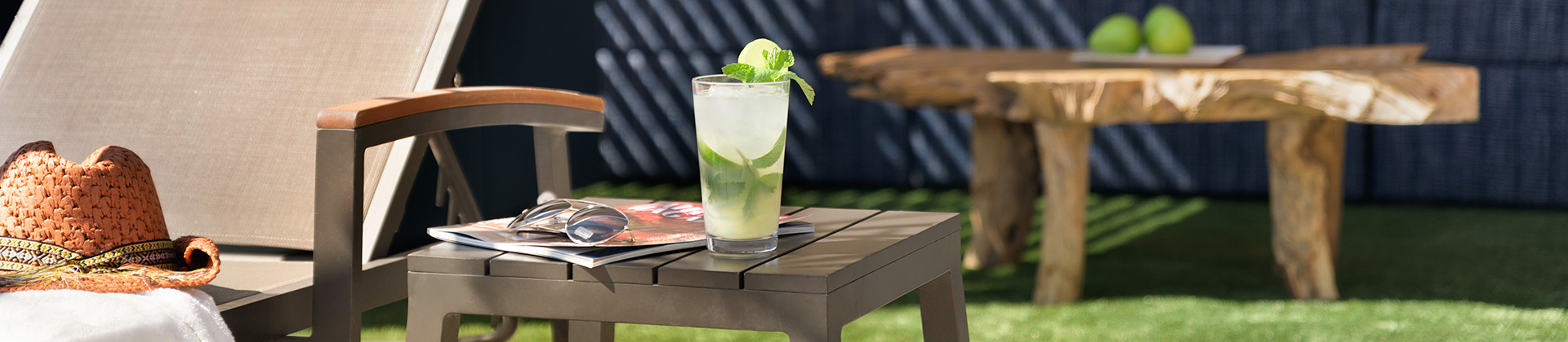 mojito sitting outdoors on an table next to a pair of sunglasses