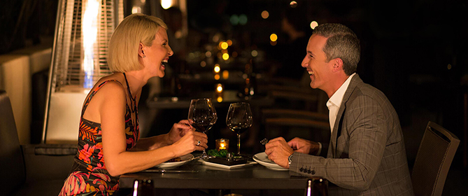 man and women laughing over drinks at bourbon steak