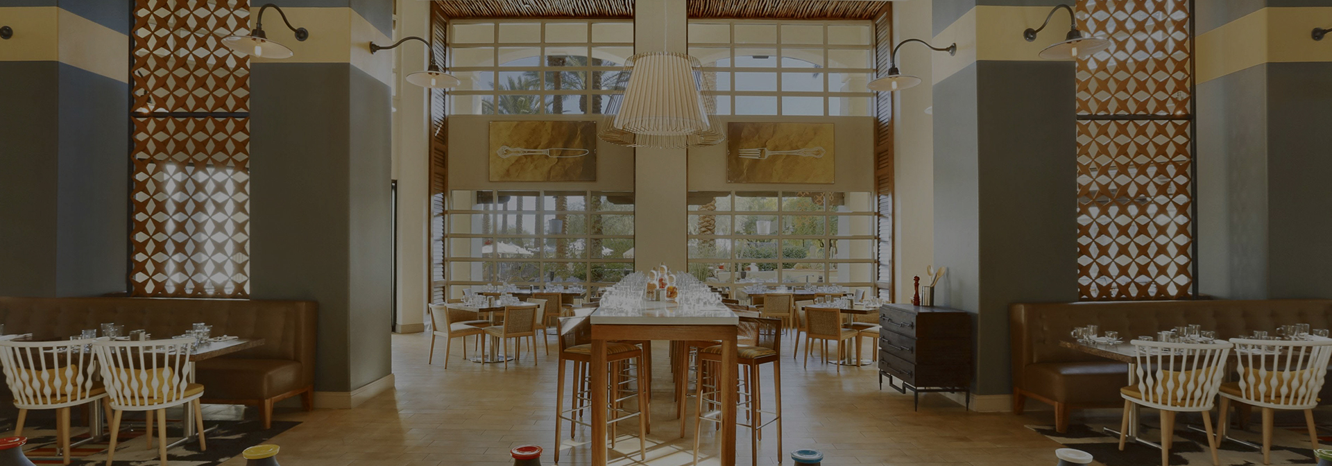 a light green and yellow colored dining room with tables set for service