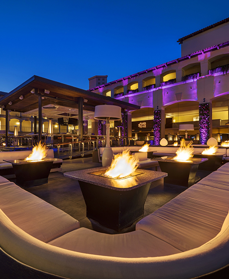 outdoor lounge area with lots of fire pits and soft lighting