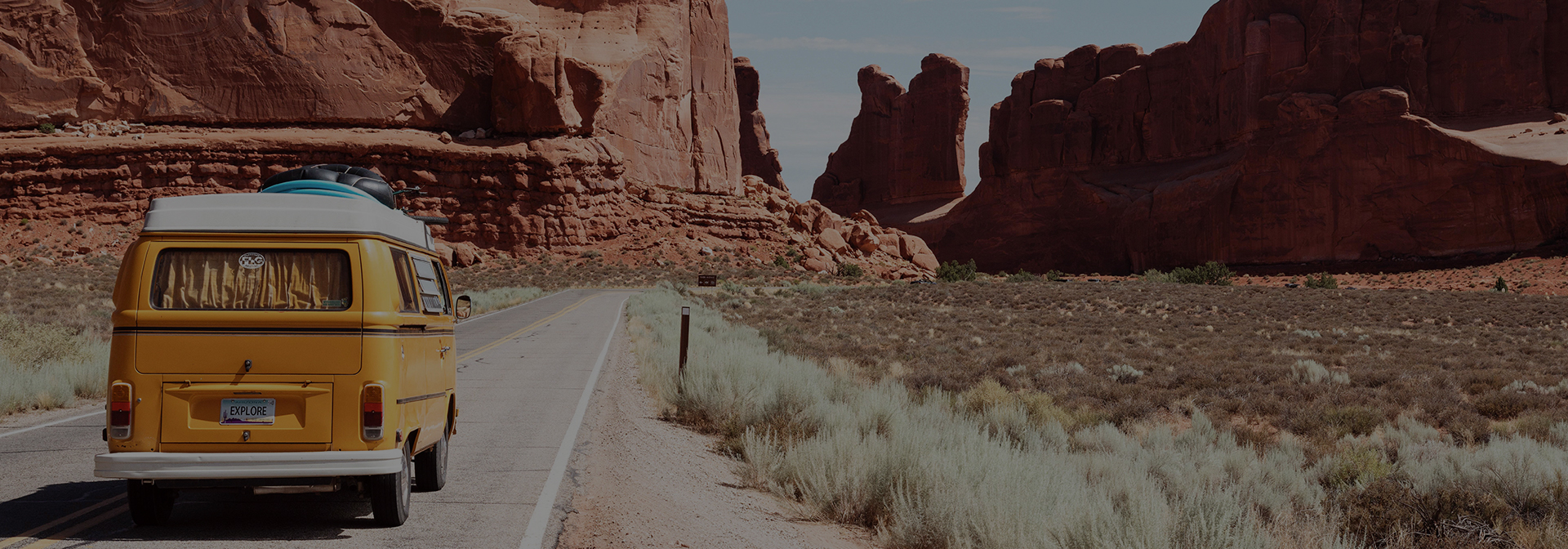 a retro yellow van driving through the desert