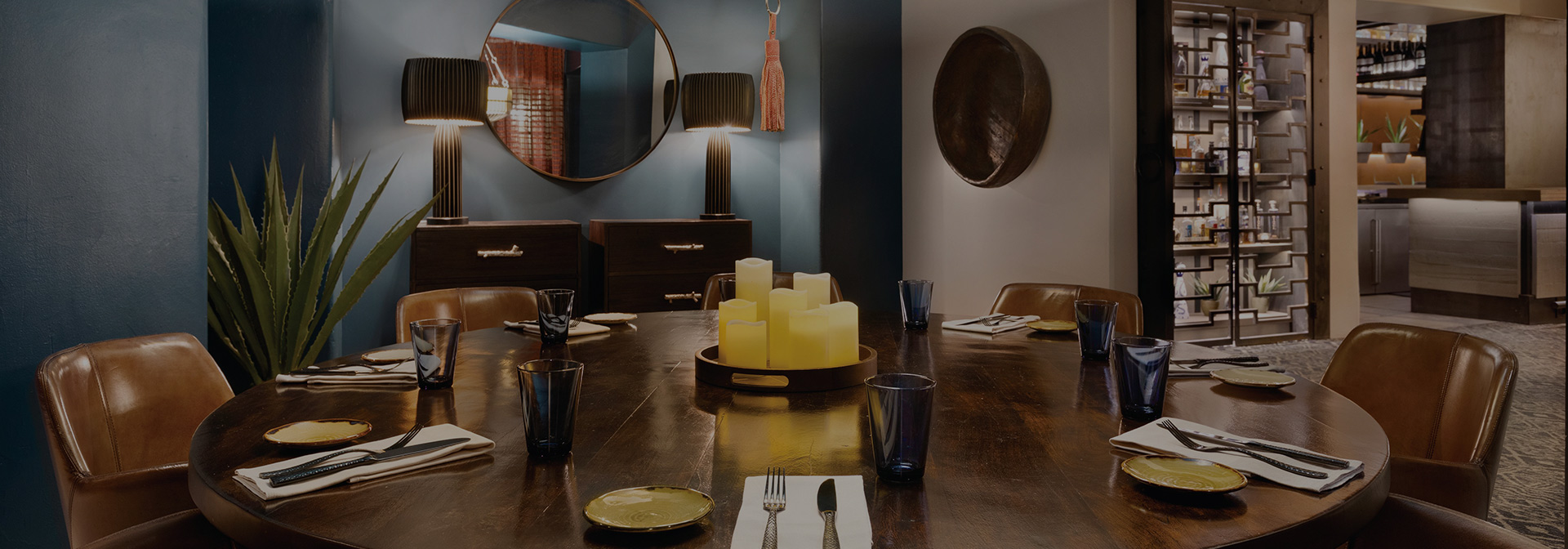 a large round table with candles in the middle and ready for service