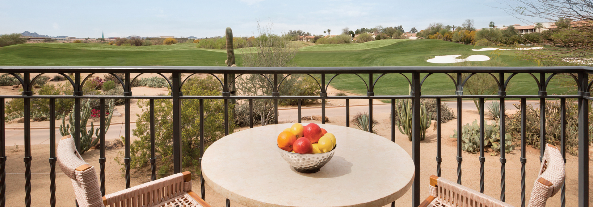 a small round table with a bowl of fresh fruit in the middle