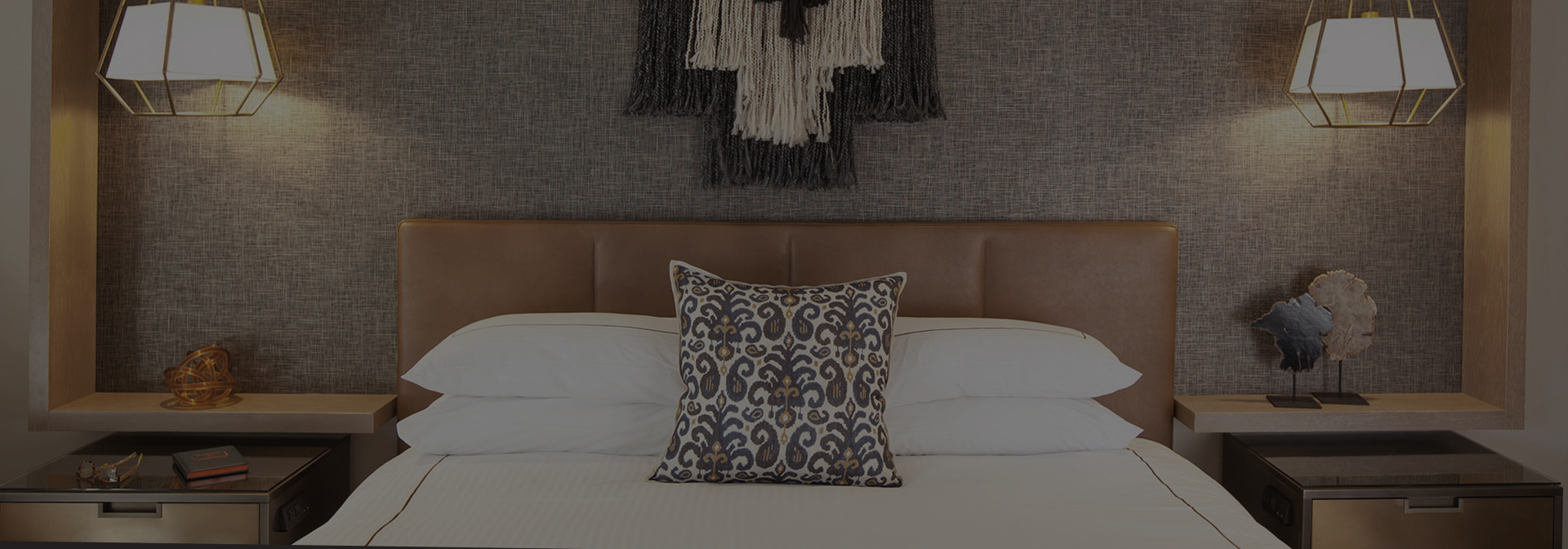 a bed with pillow and artwork hanging over it