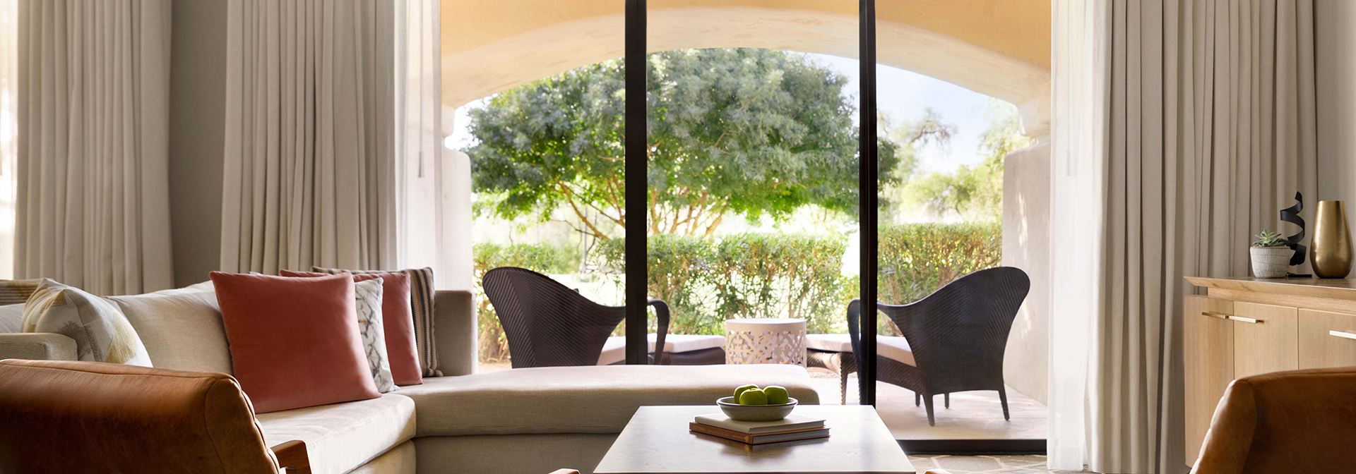 a living room with couch and chairs and sliders that open to a patio