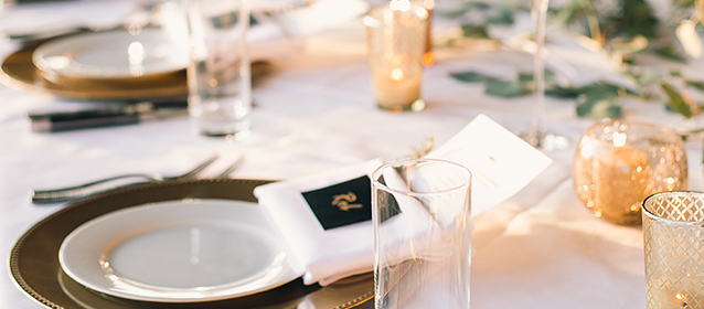close up of a table with small gold candles and chargers