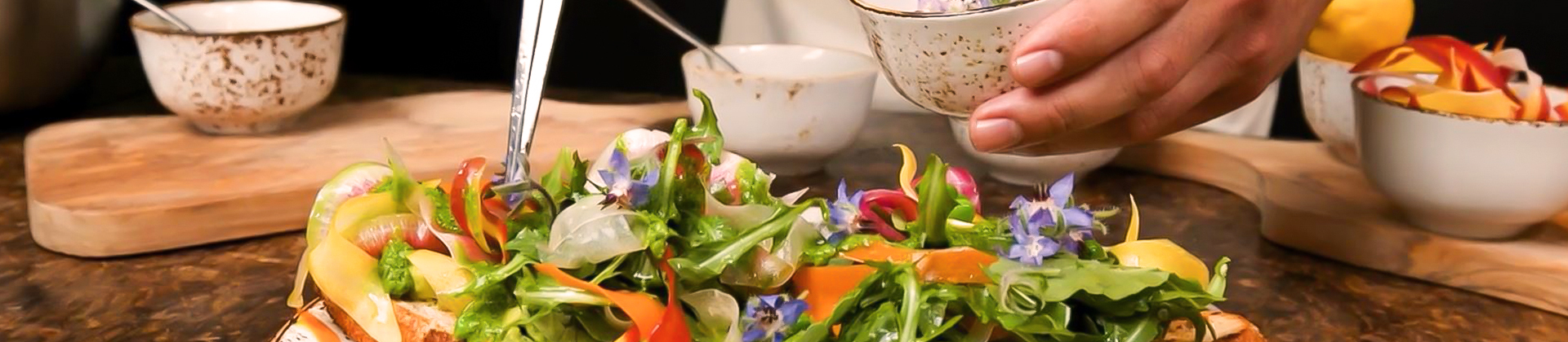 chef putting some dressing on a salad