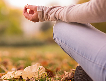 person meditating in a field