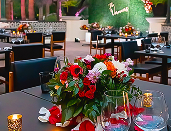 tables with colorful flowers in the middle and small tealight candles