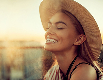 smiling woman wearing a sunhat