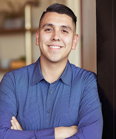 a smiling man wearing a blue button-up shirt
