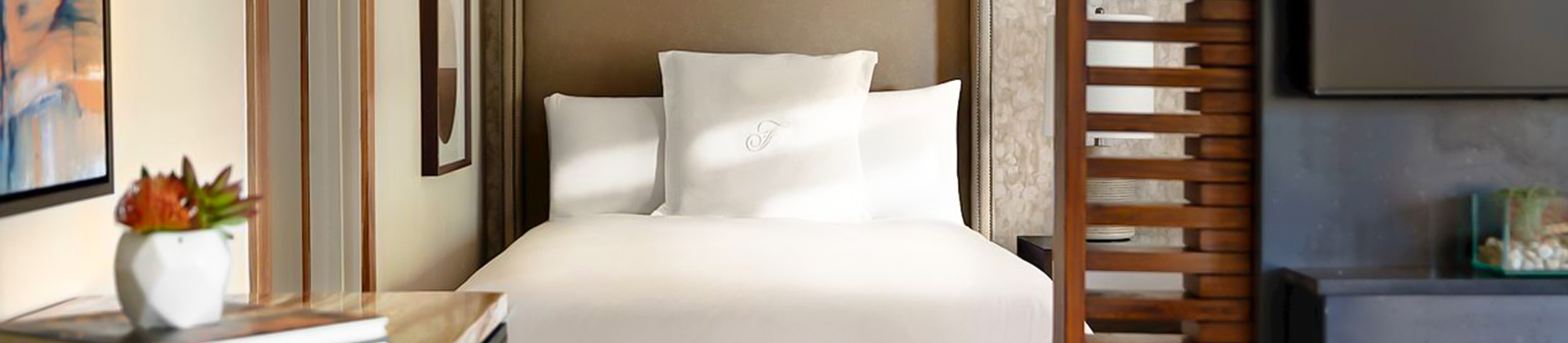 a large bed in a room with the sun shining in from the windows